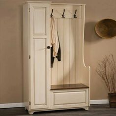 a white wooden bench sitting under a coat rack