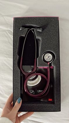 a woman's hand holding up a box with a stethoscope in it