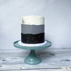 a white and black cake sitting on top of a wooden table