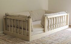 a baby crib in the corner of a room with a rug on the floor