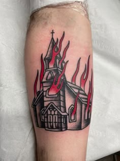 a black and red tattoo with a church on fire in the middle of its arm