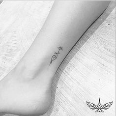 a black and white photo of a woman's foot with a small tattoo on it