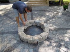 a man bending over to build a fire pit