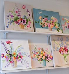 four canvases with flowers painted on them are hanging on the wall next to each other