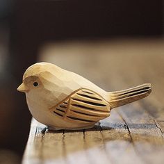 a wooden bird sitting on top of a wooden table