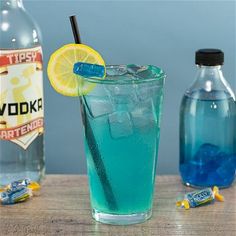 a blue drink with ice and lemon wedges