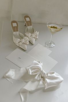 wedding shoes, napkins and wine glass sitting on a table