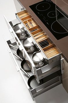 an oven with pots and pans in it next to a stove top on a counter