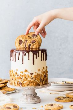 someone is decorating a cake with chocolate chip cookies