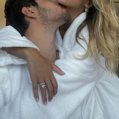 a man and woman kissing while wrapped in towels