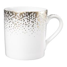 a white coffee cup with gold dots on it