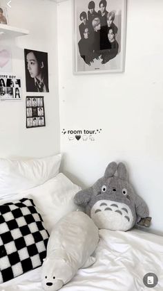 a bedroom with white walls and black and white pictures on the wall above the bed