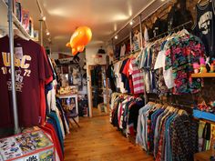 the inside of a clothing store with t - shirts on display