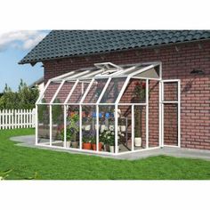 a brick building with a white glass greenhouse