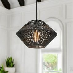 a light fixture hanging from the ceiling in a room with white walls and wooden floors