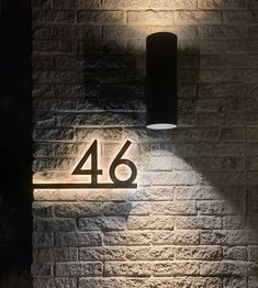 a light that is on the side of a brick wall next to a number 46