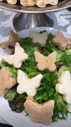 a white plate topped with lettuce and crackers on top of a table