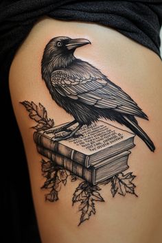 a black bird sitting on top of a book with leaves around it's legs