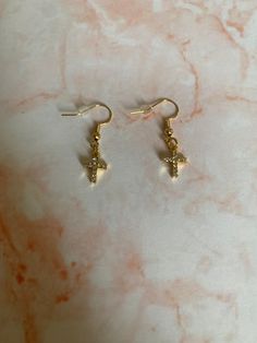 Beautiful gold and white shiny cross drop earrings. Cross Earrings Aesthetic, Gold Cross Pendant Earrings As Gift, Elegant White Cross Earrings, Gold Cross Pendant Earrings For Gift, 14k Gold Cross Earrings, Gold Hypoallergenic Cross Earrings, Gold Cross-shaped Pierced Earrings, Dangle Cross Earrings, Cross Earrings