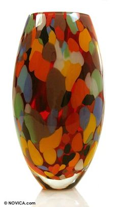 a colorful glass vase sitting on top of a white table