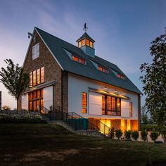 a large white house with lots of windows and lights on it's roof at night