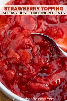 a white bowl filled with strawberry jam on top of a wooden table next to a spoon