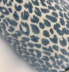 a blue and white leopard print pillow on a table