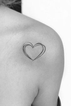 a black and white photo of a woman's shoulder with a heart tattoo on it