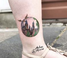 a woman's leg with a tattoo on it that has a castle in the middle