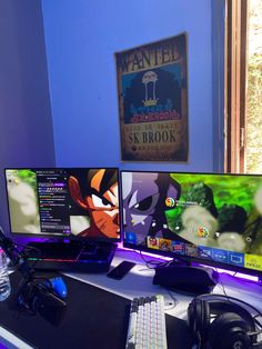 two computer monitors sitting on top of a desk next to a keyboard and headphones