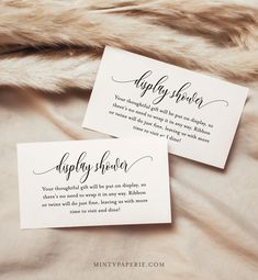 two cards with calligraphy on them sitting on a fur - lined bed sheet that says happily married