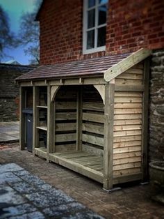 a wooden shed with a red brick building in the background