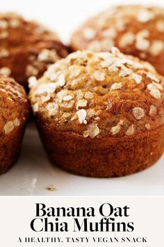 several muffins with oats on top sitting on a white surface, close up