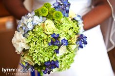 a bride holding a bouquet of green and blue flowers