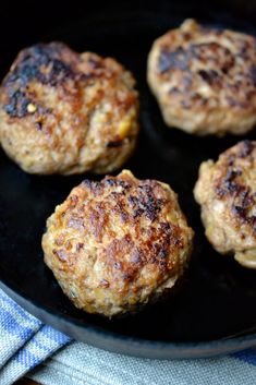 four hamburger patties in a skillet ready to be cooked