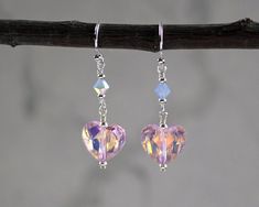 "Beautiful color combination of pink and periwinkle crystal heart earrings. They are made with pink AB crystal hearts, periwinkle crystal bicones, accented with tiny silver beads. The AB element catches and reflects the color around the crystal. They dangle 1\" from sterling silver ear wires. ❖ 12x10mm Celestial crystal hearts ❖ 4mm Swarovski crystal bicones ❖ silver fill ❖ sterling silver Earrings shown are on french hook ear wires. All earring types are sterling silver with the exception of cl Celestial Crystal, Crystal Heart Earrings, Handmade Jewlery, Blue Crystal Earrings, Wrap Earrings, Swarovski Crystal Jewelry, Beads Earrings, Dream Girl, Wire Wrapped Earrings