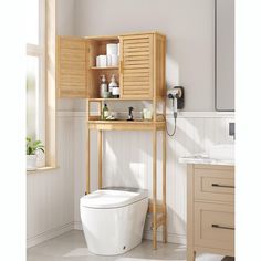 a white toilet sitting next to a wooden cabinet