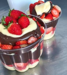 two dessert cups with strawberries and chocolate on the top one is filled with whipped cream