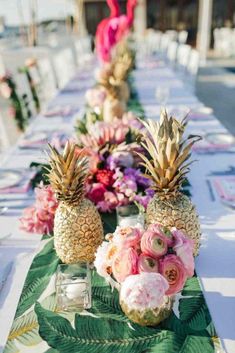 pineapples and flowers are lined up on a long table