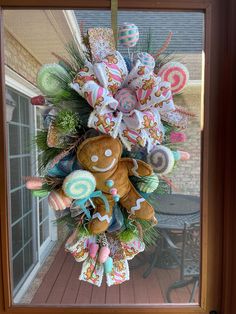 a door hanger decorated with candy and a gingerbread man on the front porch