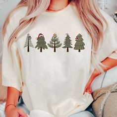 a woman wearing a white t - shirt with christmas trees on it