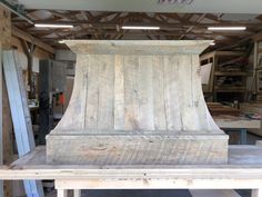 a wooden stove top sitting on top of a table in a room filled with wood