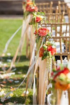 rows of wooden chairs lined up with flowers and ribbons tied to the back of them