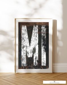 the letter m is made out of wood and has been painted white with black stripes