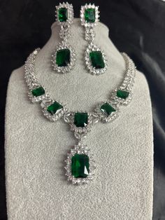 Gorgeous fine quality replica diamond and emerald green studded necklace with a white  rhodium plating and matching Earrings Item contains: Necklace and earrings AAA-quality cubic zirconia was used. Highest quality and craftsmanship Necklace Fitting is adjustable Earrings Closure: Pushback Necklace Closure: chain with Hook Formal Silver Jewelry Sets With Emerald, Formal Silver Emerald Jewelry Sets, Green Crystal Rhinestone Necklace, Silver Emerald Jewelry Sets For Anniversary, Green Sparkling Stones Jewelry Sets For Party, Green Crystal Jewelry Sets With Jewels, Green Crystal Jewelry For Party, Silver Emerald Jewelry Sets In Fine Style, Silver Emerald Fine Jewelry Sets