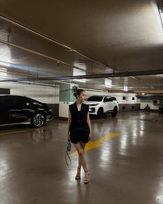 a woman in a parking garage holding a tennis racquet