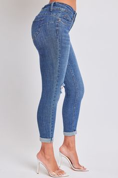 Our Women's WannaBettaButt Mid Rise Double Button Rolled Cuff Ankle Jean is your new best friend! Made with our signature butt-lifting design, these mid-waisted jeans feature slight distressed detailing along the front, optional rolled cuffs, a classic five-pocket construction, double-button closure with front zip, and belt loops. Pair with a crochet crop top for a trendy look. Measurement (Based on size 5) - Inseam (Cuffed): 27” - Rise (To top edge of band): 8” - Leg Opening: 9.5”- Model 1 is wearing a size 1. Model 2 and Model 3 are wearing a size 3. Machine wash cold. 99% Cotton/ 1% Spandex Trendy Denim Bottoms With Cuffed Ankles, Stretch Mid-rise Bottoms With Rolled Hem, Trendy Bottoms With Rolled Hem And Cuffed Ankles, Trendy Bottoms With Cuffed Ankles, Denim Bottoms With Rolled Hem And Cropped Leg, Blue Denim Bottoms With Cuffed Ankles, Mid-rise Medium Wash Bottoms With Rolled Hem, Cuffed Ankle Denim Bottoms For Fall, Denim Bottoms With Cuffed Ankles For Fall