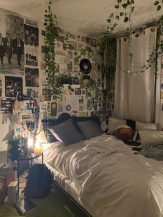 an unmade bed sitting in a bedroom next to a wall with pictures on it