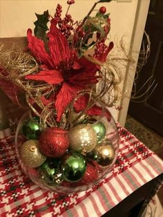 a glass bowl filled with ornaments on top of a table