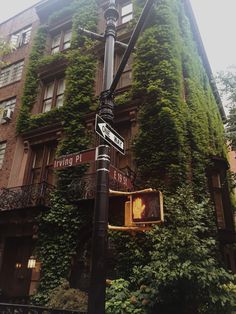 an ivy covered building with street signs on it